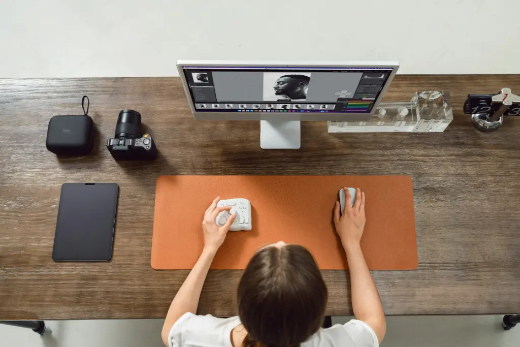 Professional cleaner sanitising a modern desk in a bright office